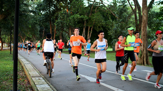 A cyclist rides head-on into the mass of runners