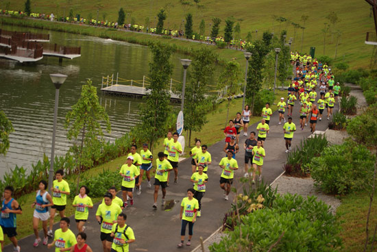 Participants clad in neon green running along the scenic waterway
