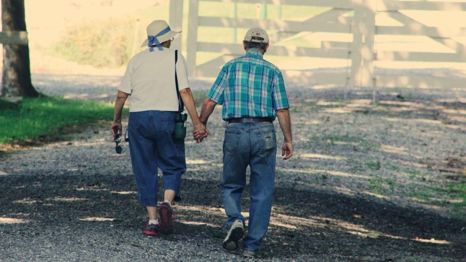 A couple holding hands while walking outdoors, showing sexual wellness as part of overall health